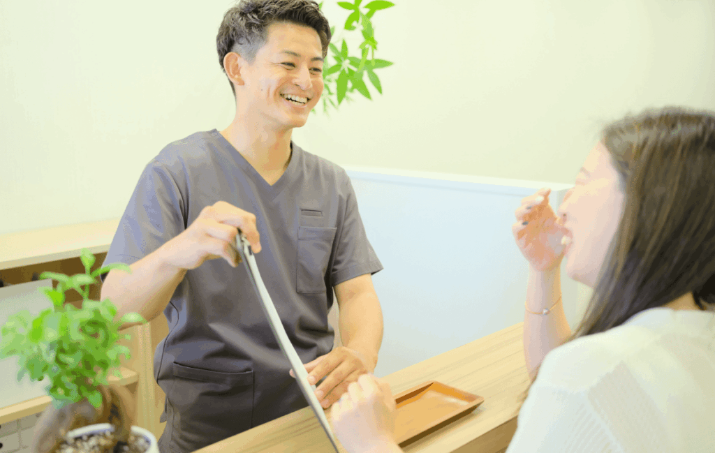 ゴッドハンドに出会え施術を受けた患者さんが喜んで笑顔になり、受付で話をしている姿。