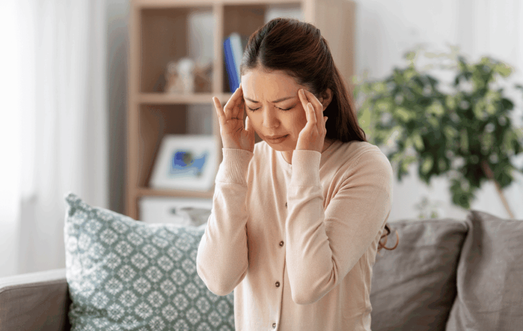 整体を受けた後に頭痛がしている女性の姿