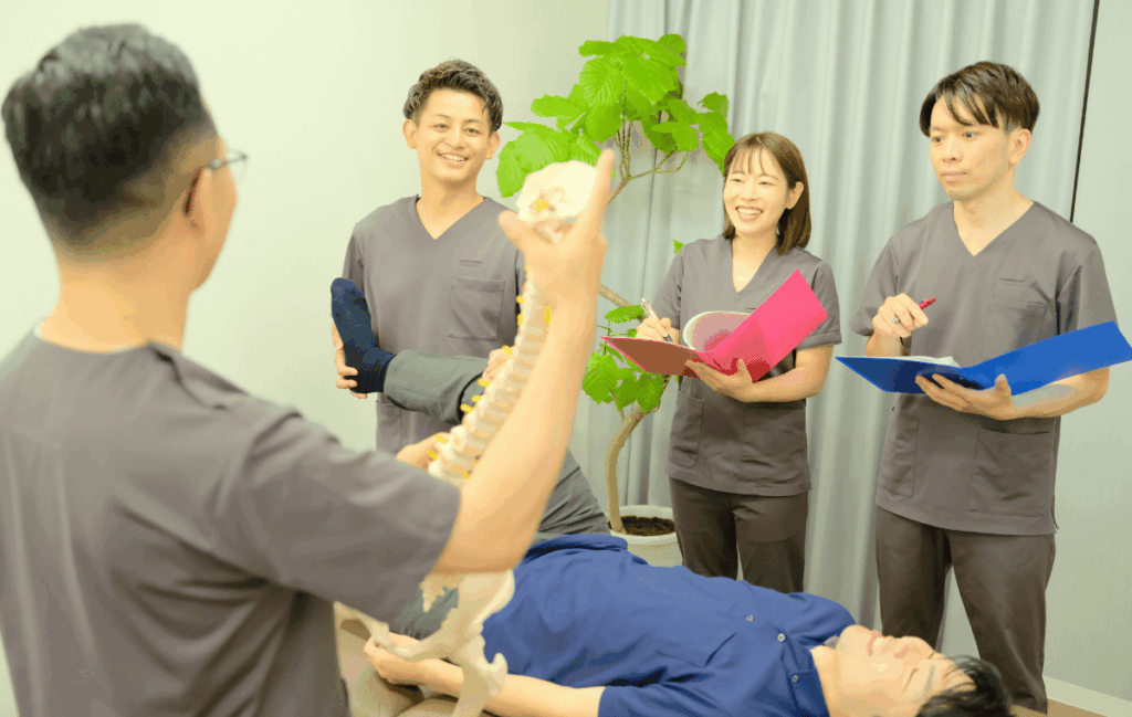 無駄な施術をなくし最大化するために、従業員に施術ポイントを院長が教えている姿