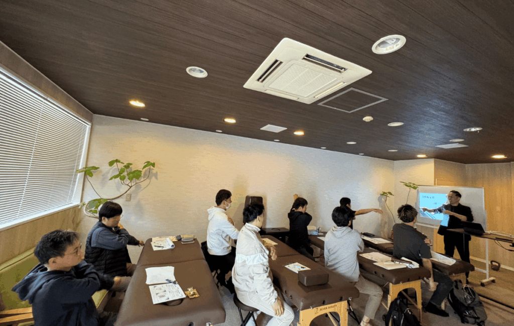 受講生がFJA理論の肘関節の講義を真剣に聞いている姿
