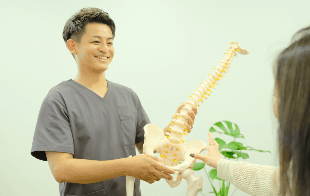 ゴッドハンドの整骨院の先生が首こりの本当の原因を女性の患者さんに説明している姿
