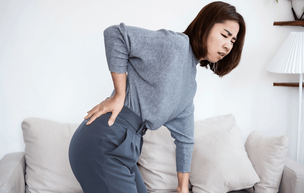 椎間板ヘルニアの女性が腰を押さえている様子
