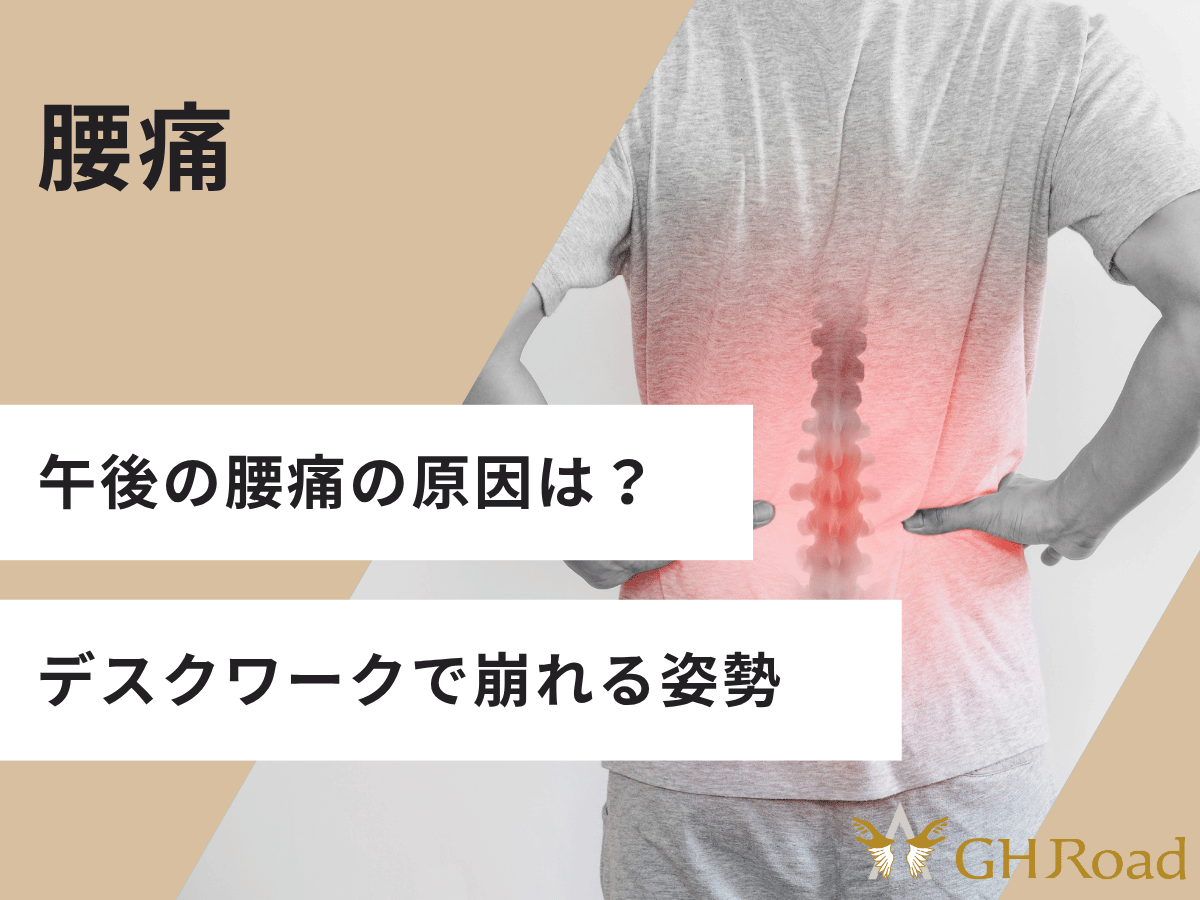 午後になると腰痛で仕事に集中できない男性の後ろ姿